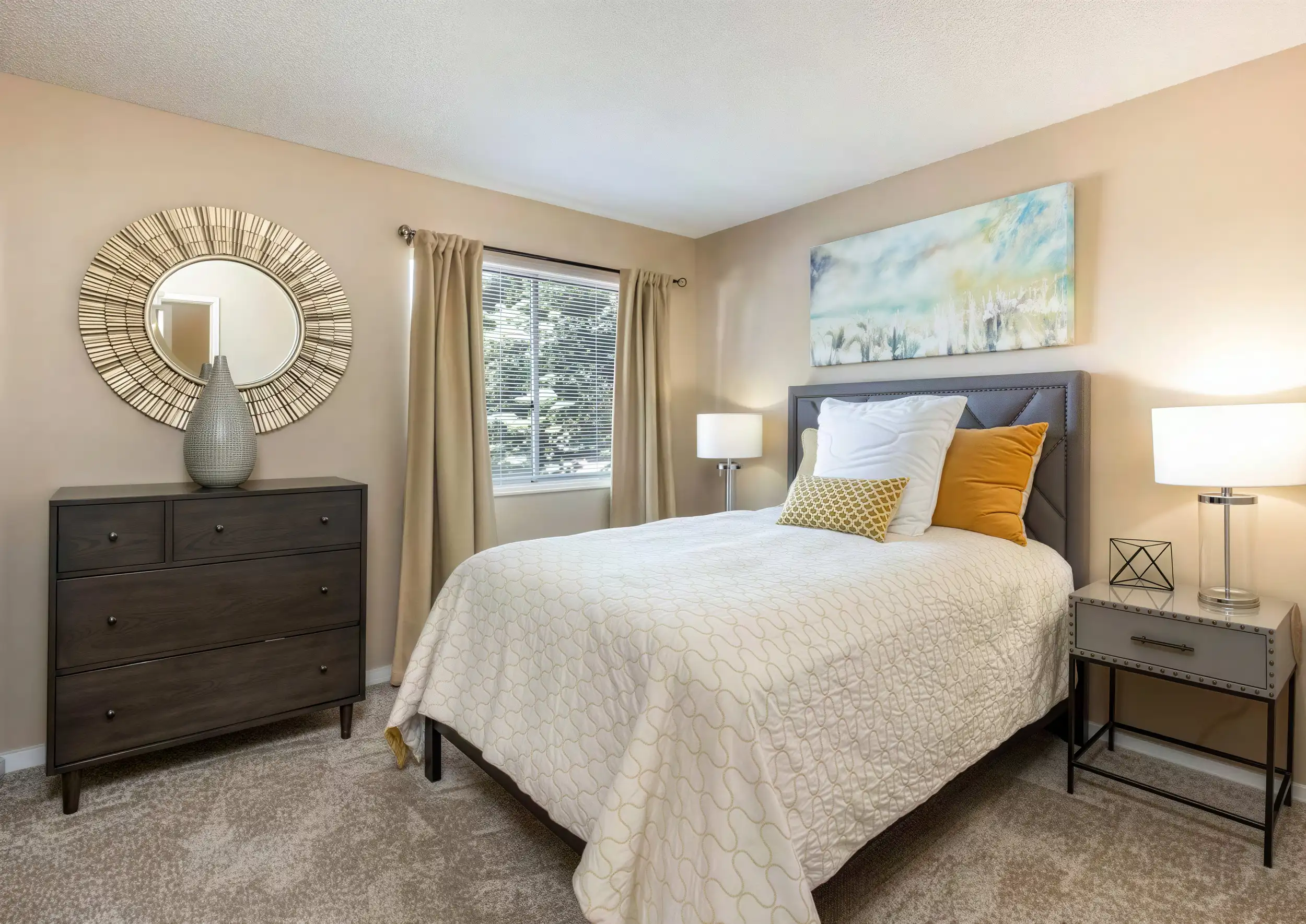 Comfortable bedroom with large window and neutral finishes in an Aurora apartment home