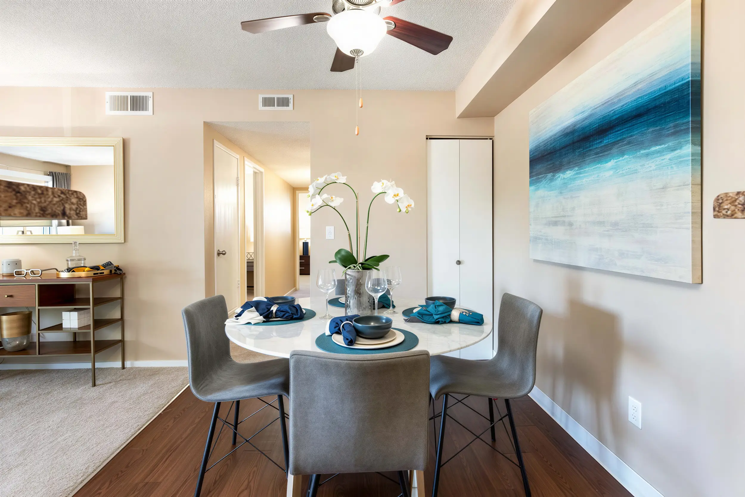 Bright apartment dining space with four chairs and contemporary décor at Cambrian Apartments
